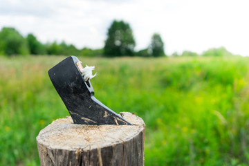 Broken axe on the background of green meadows.