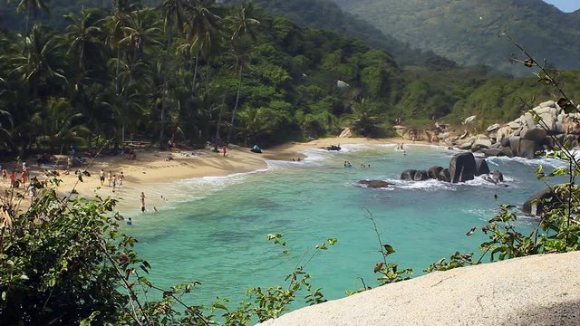 People enjoy their vacation at the ocean beach, swimming at camping and hiking area and djungle in Parque Tayrona, Colombia, a great tourist destination in Latin America for backpacking