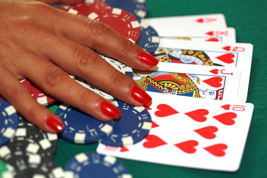Woman playing poker and chips on the green casino table