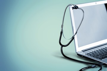 Laptop diagnosis with  stethoscope  on background