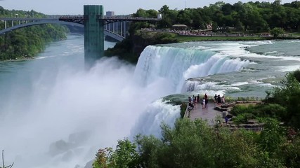 NIAGARA FALLS, USA – SEPTEMBER 3, 2018: View of American Falls with the Rainbow Bridge on September 3, 2018 in Niagara Falls, USA