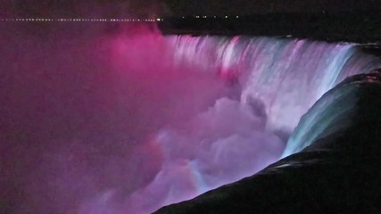 Niagara Falls lit at night by colorful lights