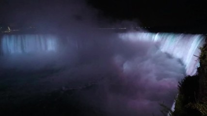 Niagara Falls lit at night by colorful lights