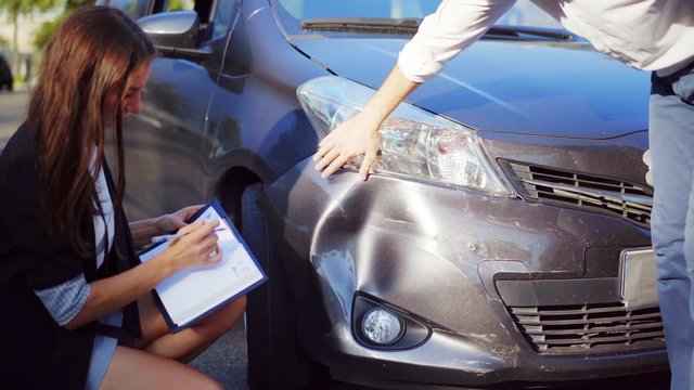 Man explaining to inspector how the car accident happened. Car crash. Broken car. 4K UHD.