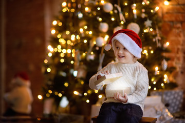 Cute little boy wearing Santa hat on Christmas eve