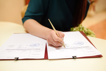 Naklejka premium Bride signing marriage license or wedding contract during ceremony