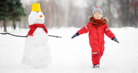 Kid during stroll in a snowy winter park