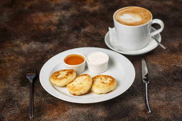 Cottage cheese curd pancakes or fritters with latte coffee