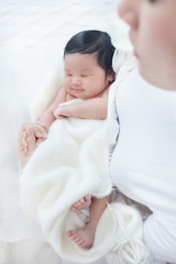 Happy beautiful asian woman looking at her sleeping baby child