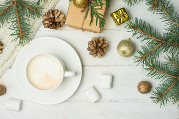 Christmas composition in Scandinavian style. Christmas gifts, coffee with marshmallows, pine cones, spruce branches on a wooden white background. Flat lay