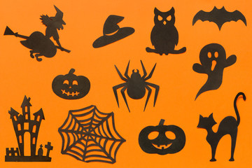 Happy Halloween Set cut out of black paper silhouettes pumpkin, witch, ghost, cat, owl, spider, web, hat, bat, castle on orange background. Concept Paper cut style. Top view