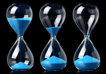 Collection of hourglasses with blue sand showing the passage of time