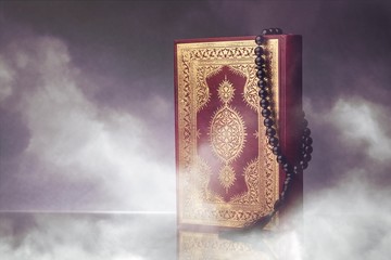 Islamic Book Koran with rosary on grey background