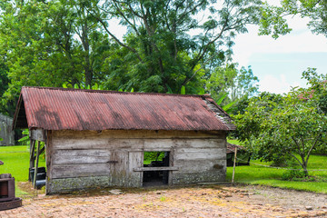 Isolated image of worn barn wood abandoned slave cabin with various antique items