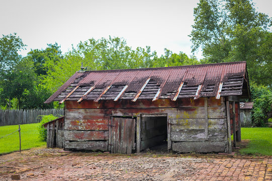 Isolated image of worn barn wood abandoned slave cabin with various antique items