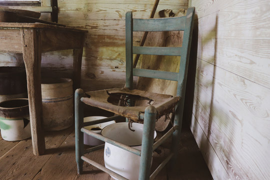 Isolated image of worn barn wood abandoned slave cabin with various antique items