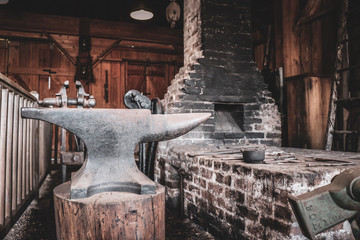 Fototapeta na wymiar Interior view of abandoned blacksmith cottage with working equipment 