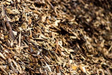 Various brown shades of wooden mulch texture with bark and lumber pieces