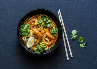 Coconut shrimp laksa soup on a dark background, top view. Copy space