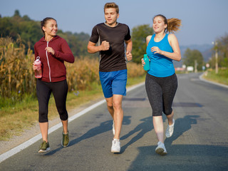 young people jogging on country road