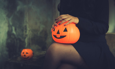 Happy Halloween. Beautiful woman in black Scary witch halloween costume holding pumpkin