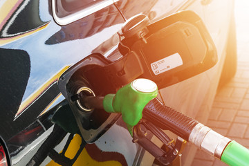 Refueling the car at a gas station fuel pump. Man driver hand refilling and pumping gasoline oil...