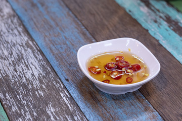 Fish sauce and pepper in a cup on the table.