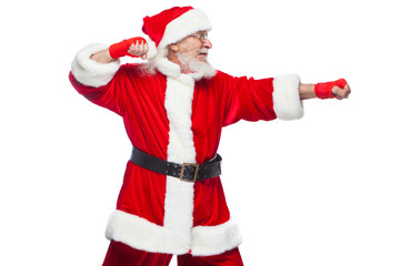 Christmas. Santa Claus with red bandages wound on his hands for boxing imitates kicks. Kickboxing, karate, boxing. Isolated on white background.
