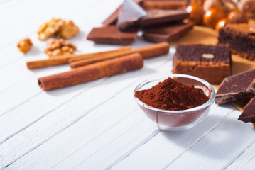 chocolate brownie cake and ingredients, baking papaer on white wood table background