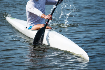Photo of a part of a kayak with a paddle and a rower. © Valerii