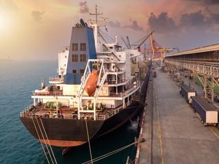 Bulk Vessel alongside at thailand port and discharging steel coil  by  ship's crane.