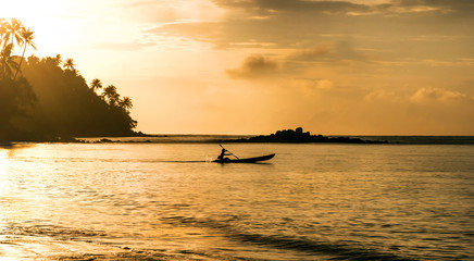 a man paddle boarding during a beautiful sunrise,silhouette