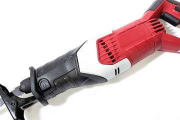 Red reciprocating saw with a blade isolated in a white background