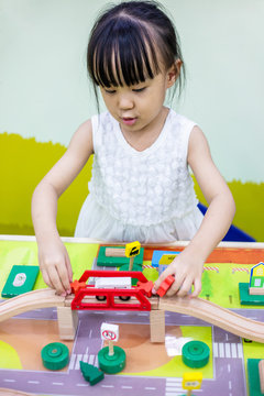 Asian Chinese little girl playing wooden toy train