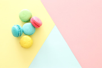 Multicolored macaroons on pastel geometric background
