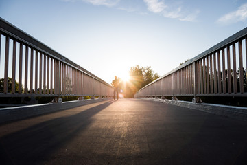 Urbane Brücke: Sonnenuntergang, Asphalt, Geländer und blauer Himmel