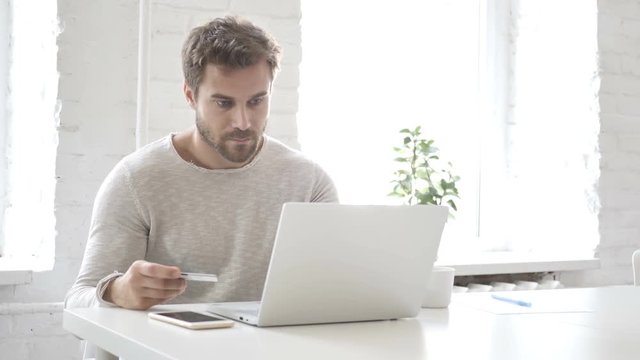 Online Payment with Debit Card  by Man on Laptop