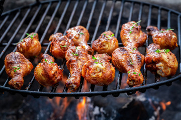 Hot chicken leg on grill with herbs and spices