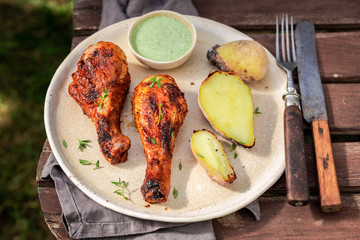 Crispy grilled chicken leg in summer garden