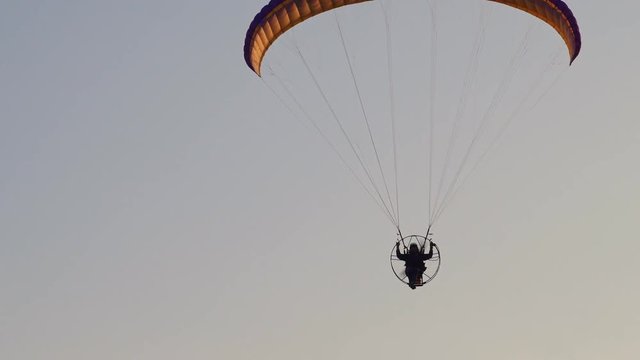 A paratrooper flies on the Power ParaChute at the sunset