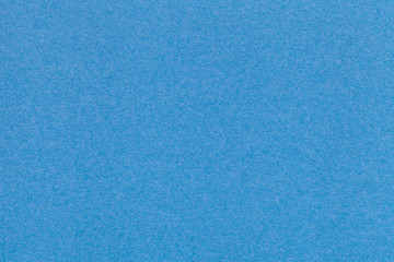 Texture of old blue paper closeup. Structure of a dense cardboard. The azure background.