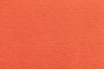 Texture of old bright orange paper closeup. Structure of a dense cardboard. The ginger background