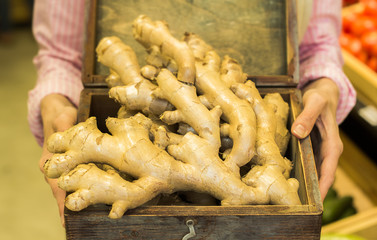 The root of ginger in the hands of the saleswoman. Raw vegetables. 