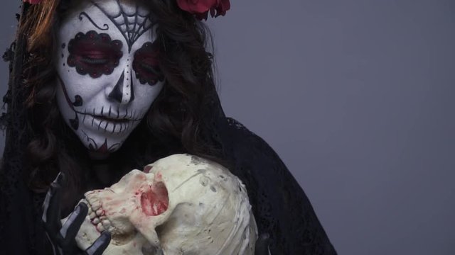 Grim Santa muerte on Halloween, the girl hugs the skull