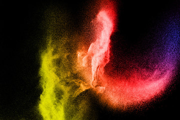 Freeze motion of color dust particles on black background.Abstract color powder overlay texture.