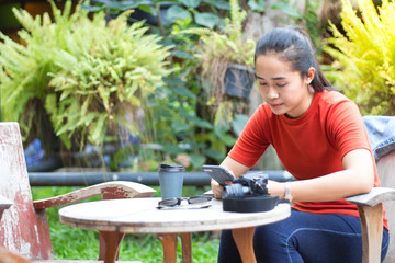 Women are playing internet on mobile phones and have a camera, sunglasses, a coffee cup is on a...
