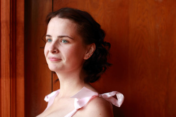 Fototapeta premium Fine emotional brunette on old style wall, close up portrait. Yonge girl in vintage pink pastel with live expressions on beautiful country and old background.