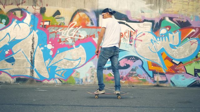 A skater rides his board in a skatepark. 4K.