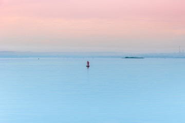 Fototapeta premium Sunrise - river landscape with a buoy in the fog