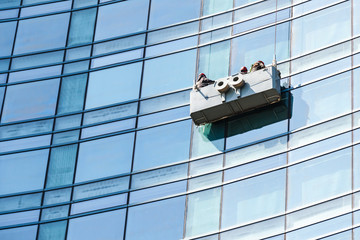 Blue glass facade cleaning with cradle